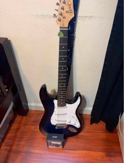 Guitar with pick strap and mini amp.