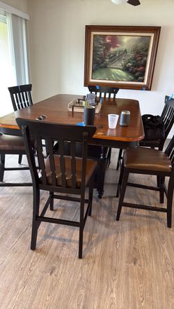High table with 6 high leather chairs with extension and a glass top in good condition
