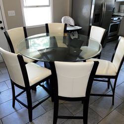 Gorgeous 48” glass counter height table and 4 chairs and lazy Susan. Additional Two chairs Available for  $190. Barely used the dining set, due to hav
