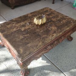 Beautiful rectangular coffee table featuring a brown marble top and a carved wooden base. Very solid and heavy