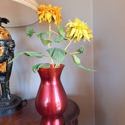 Red glass vase with flowers included, vase is 8 1/2 in tall