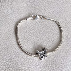 Silver tone bracelet with baby carriage charm.