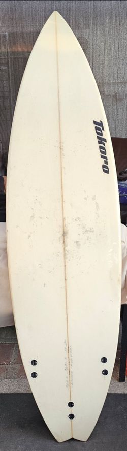Tokoro surfboard features a performance-oriented shape, prominently branded with black lettering.Brand: Tokoro Surfboards, known for high-performance