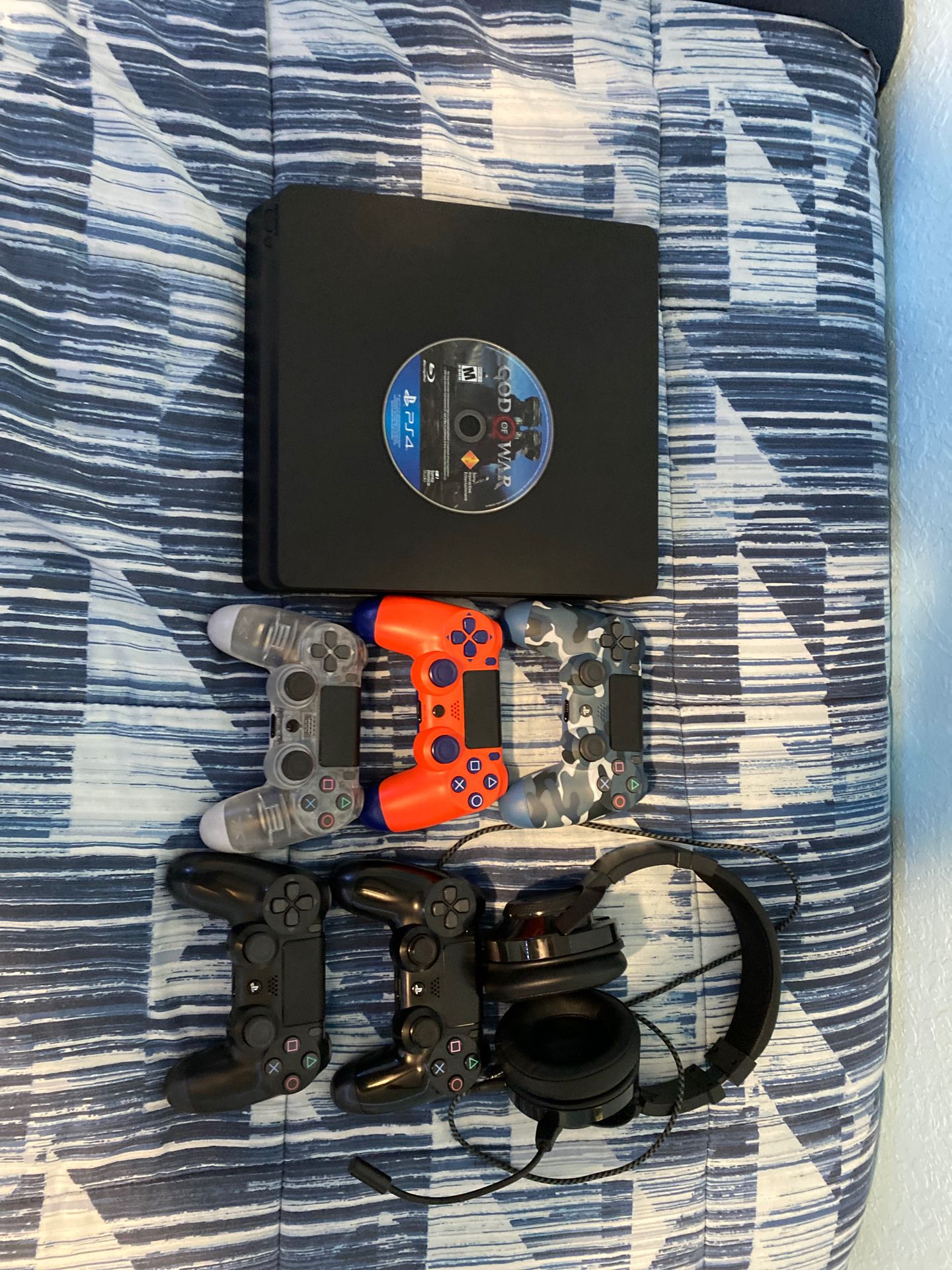 -PlayStation4 with five wireless controllers (4 used and one new), a pair of headphones and a disc game (God of War). PlayStation4 con cinco control