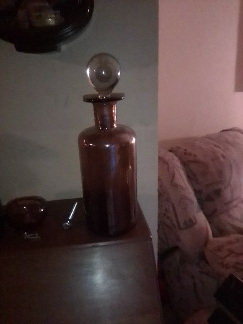 Heavy. See. Thru. Bottle. With. A. Brownish. Color. With. A. Round. Top