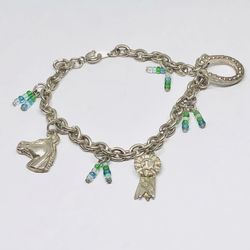 Silver tone charms bracelet with horse, horseshoe and 1st place trophy