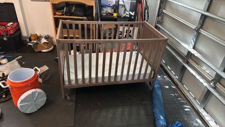 Brown crib with mattress