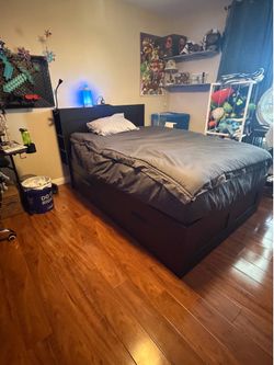 Full sized black storage platform bed with headboard