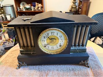 Antique mantel clock is manufactured by The E. Ingraham Co. of Bristol, Conn. This piece has a black finish with green marbleized accents and ornate g