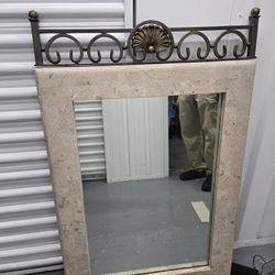Stone-look mirror with metal scrollwork 