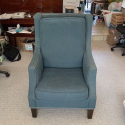 Mid-century modern upholstered armchair with nailhead detail.