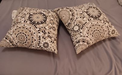 Two throw pillows multicolor, black, tan, white.