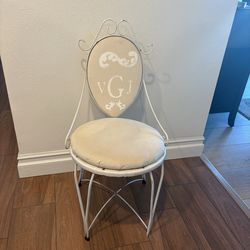 Vintage white wrought iron chair with a cushioned seat