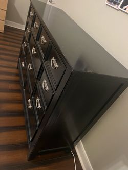 Large black dresser with 12 drawers and a matching mirror