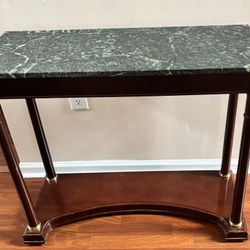 A stunning neoclassical inspired console table by Bombay Company. Made from Mahogany with a green marble top and brass accents. Circa 1989. Condition 