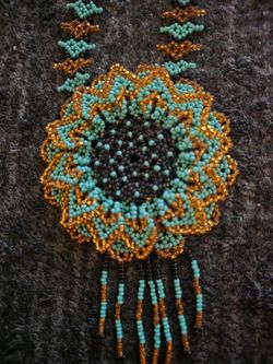 This is a contemporary Mexican handmade Huichol-style beaded sunflower pendant necklace.
