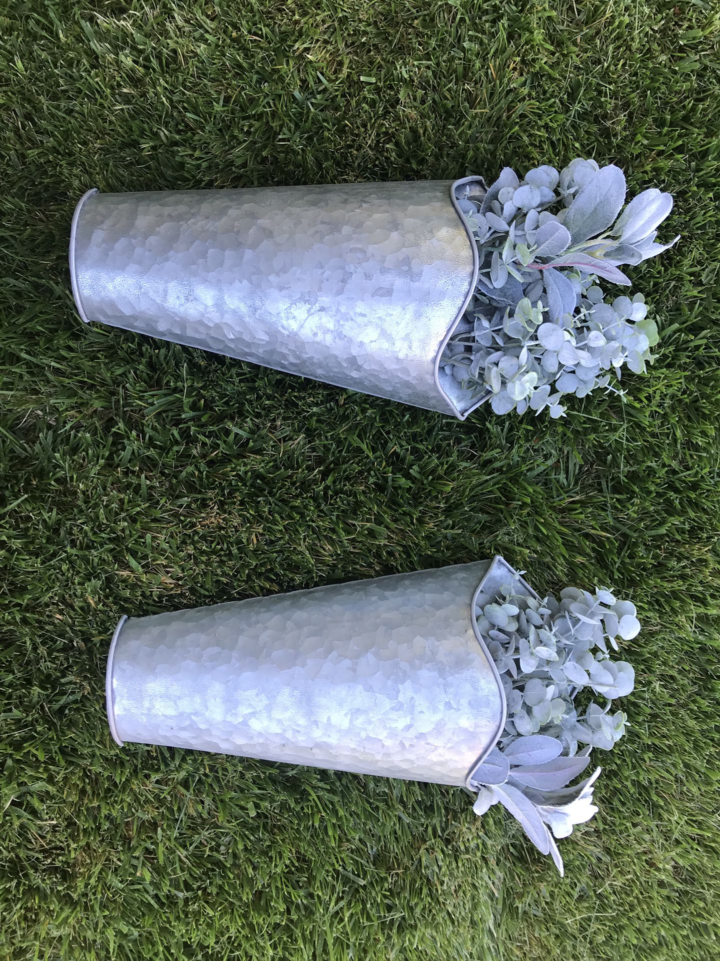 Two metal galvanized wall hanging planters. Fake plants included