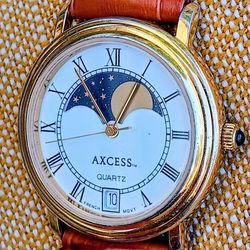 Wonderful vintage French quartz watch by Axcess, featuring a moon phase and date display, in a gold tone.