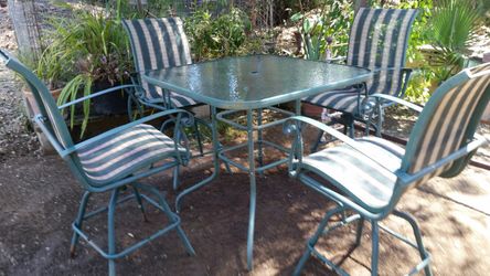 Outdoor Tall glass top table with 4 chairs.