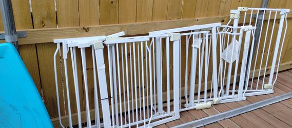 Four baby gates and assorted end pieces