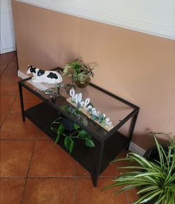 WOOD AND GLASS COFFEE TABLE WITH METAL EDGES.