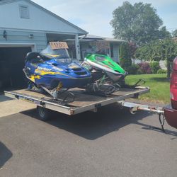 Two Snowmobiles In A Trailer