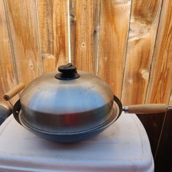 Wok pan with cover lid and grill inside.