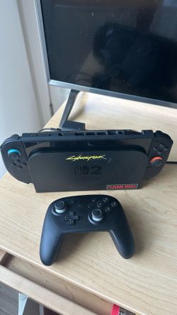 Nintendo Switch console with Pro Controller, Cyberpunk, Mario kart world, and grip case.