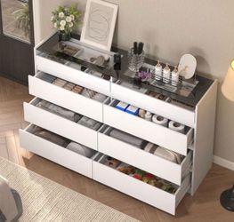white dresser/storage organizer with a sleek minimalist design and smoked glass top.