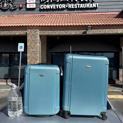 Set of 2 hard-shell rolling suitcases in good working condition.