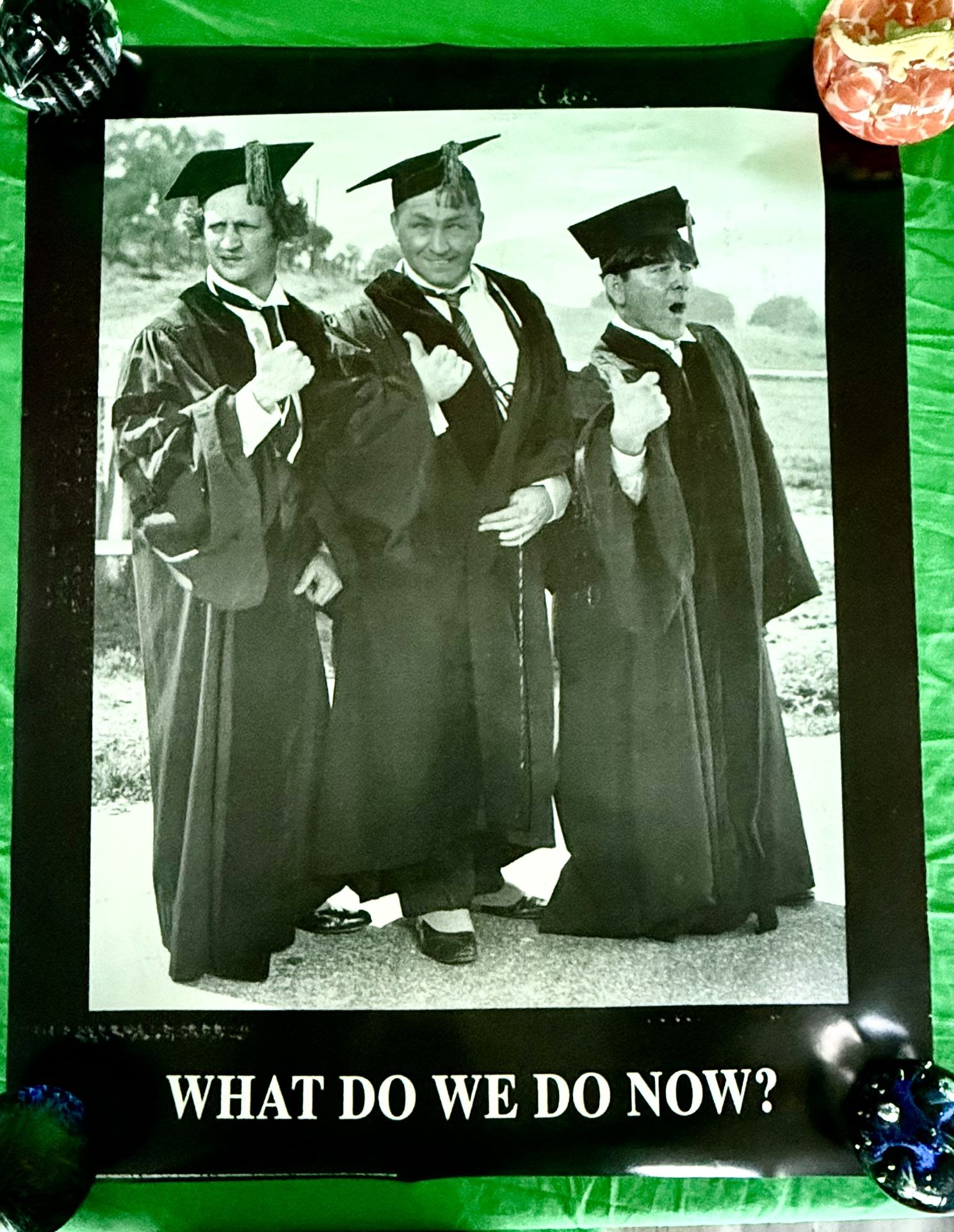 Three Stooges dressed in graduation caps and gowns. The caption “WHAT DO WE DO NOW?”
