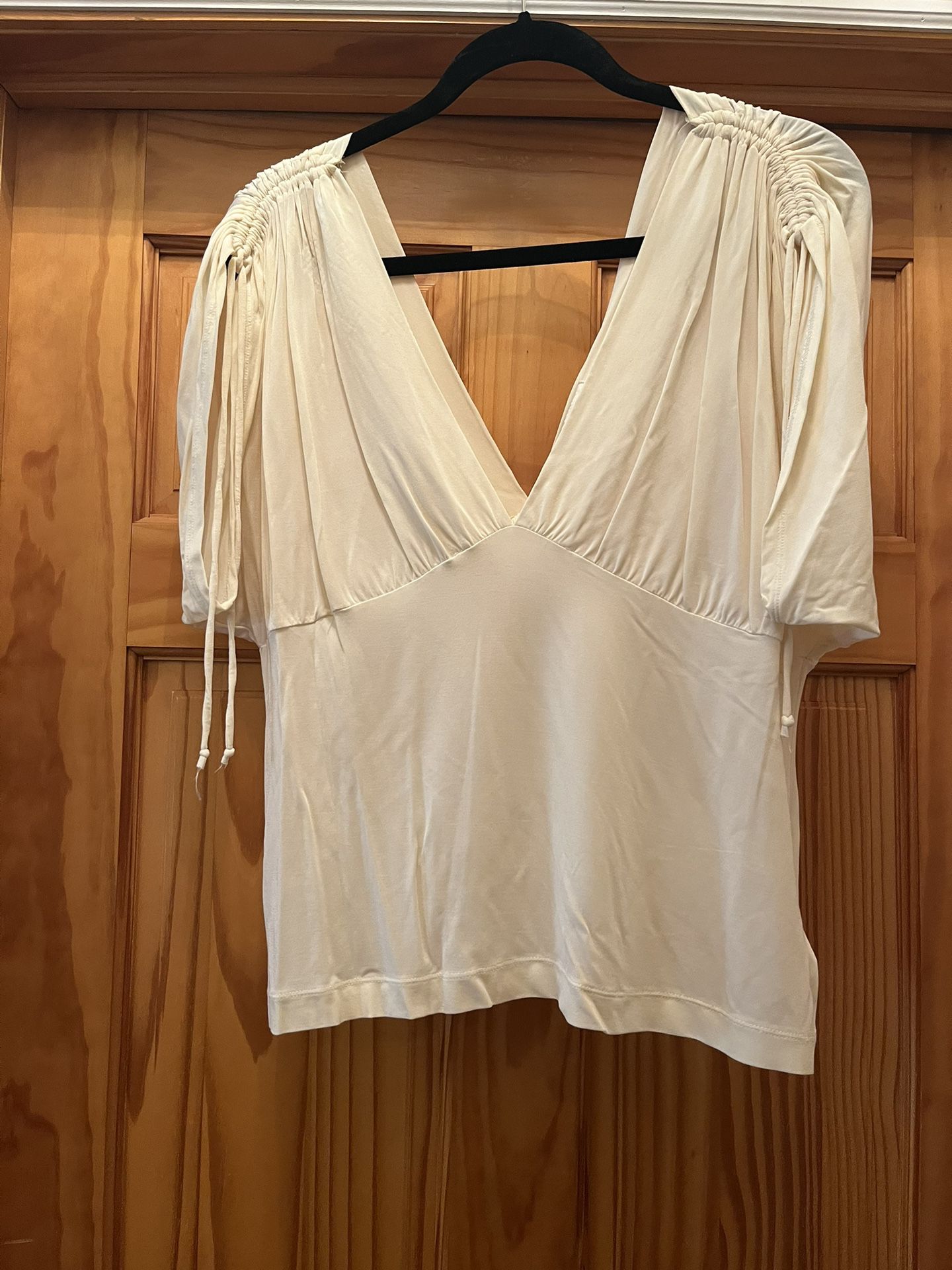 Banana Republic top for women, dressy design on top of each arm. Color white. In great condition. Size Xl Stretchy material. Made in Korea