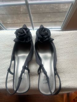 Worthington Rosie black satin slingback pumps featuring a rosette detail and a kitten heel.