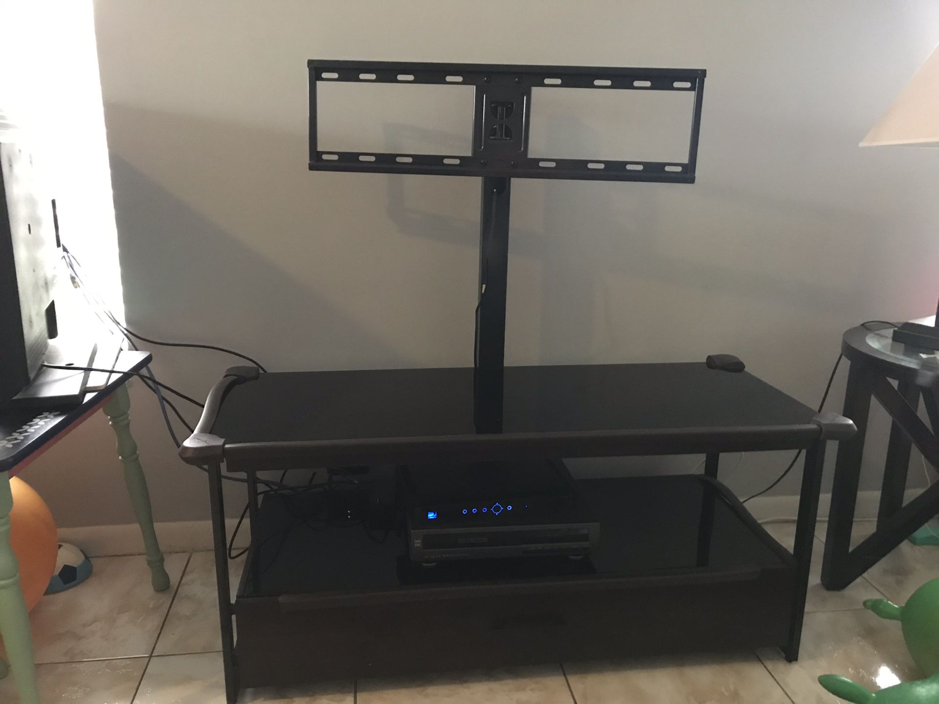 New Tv stand with drawer, can hold up to 65” tv. It has the rubber safety pads on the edges and corners since we have kids but they come off no probl