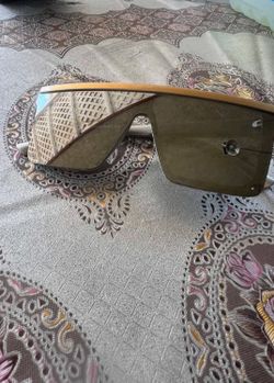 Versace VE2197 sunglasses feature a gold frame and gray-black lenses