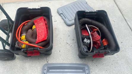 Two black tubs with RV hoses and blocks