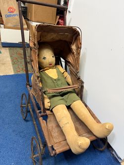 1920s Authentic Antique metal/Wood frame doll carriage or buggy with a folding canvas canopy and a antique cloth and painted-face doll featuring a han