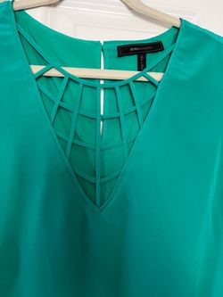 . It’s A Beautiful blouse made by BCBG it’s 100% silk. The color is green. The size is large. It is for women.