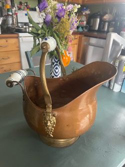 vintage copper and brass coal scuttle bucket features classic ornate brass lion head mounts and blue-and-white Delft style ceramic handles. Cash only