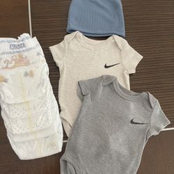 Two NIKE Onesies with hat,five Huggies diapers (size 1)
