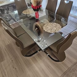 Glass dining table with 6 brown chairs