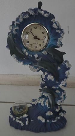 Dolphin ocean wave decorative clock with mini snow globe. Resin figurine, Olpritz clock. Size:12"H x7"W. Works, battery operated. Makes a nice gift. $