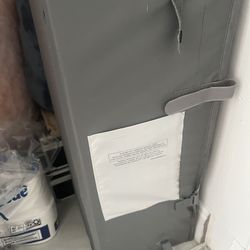 portable baby playard or crib partially folded and packed in its carrying bag.