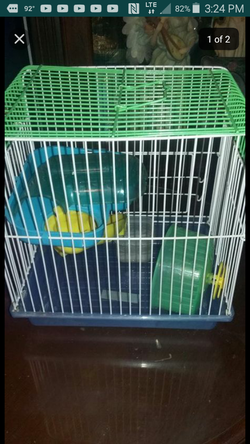 Hamster cage with toys and dish.