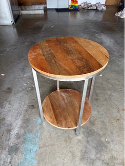 Round Natural wood and stainless steel end table.