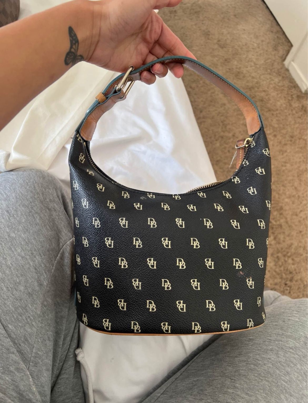 Dooney & Bourke logo bucket hobo purse  in black Coated with light blue trim
