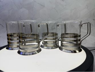 Set of (4) Axentia Tebino tea glass featuring a stainless steel holder with a distinctive slotted design.