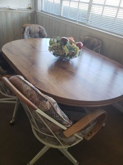 Biege dining table w/4 cloth swivel chairs. 59" X 42" oval shape. 42" X 18 " center leaf