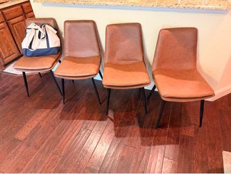 Four brown pleather dining/living chairs