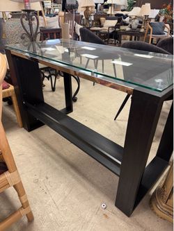 modern glass-top desk features a dark wood  - 48” x 22